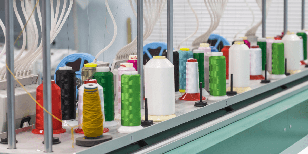 Colorful embroidery thread spools on commercial embroidery machine at Grasel Graphics in Frankenmuth, MI